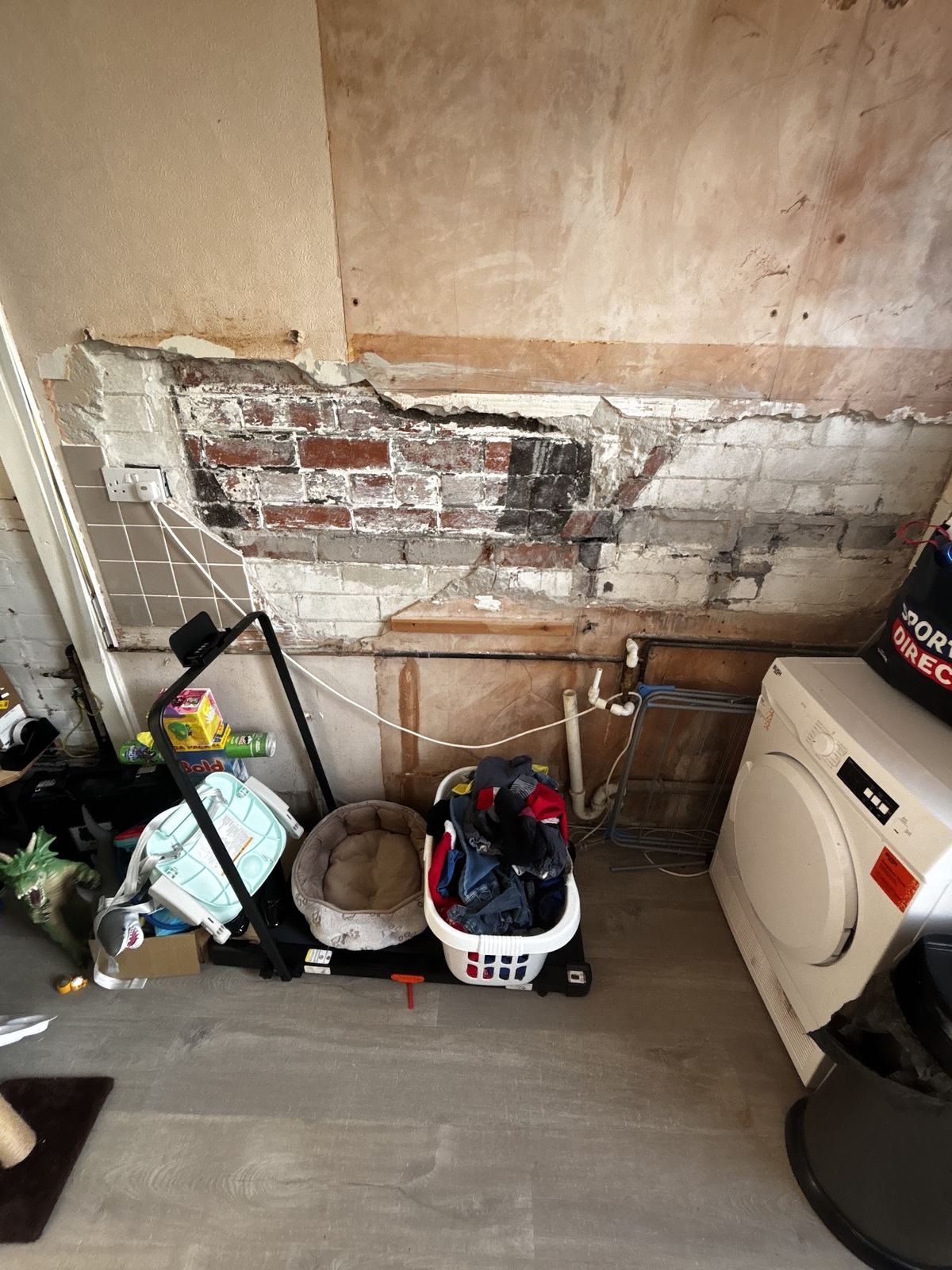 Wall hacked back to bare brick before plastering